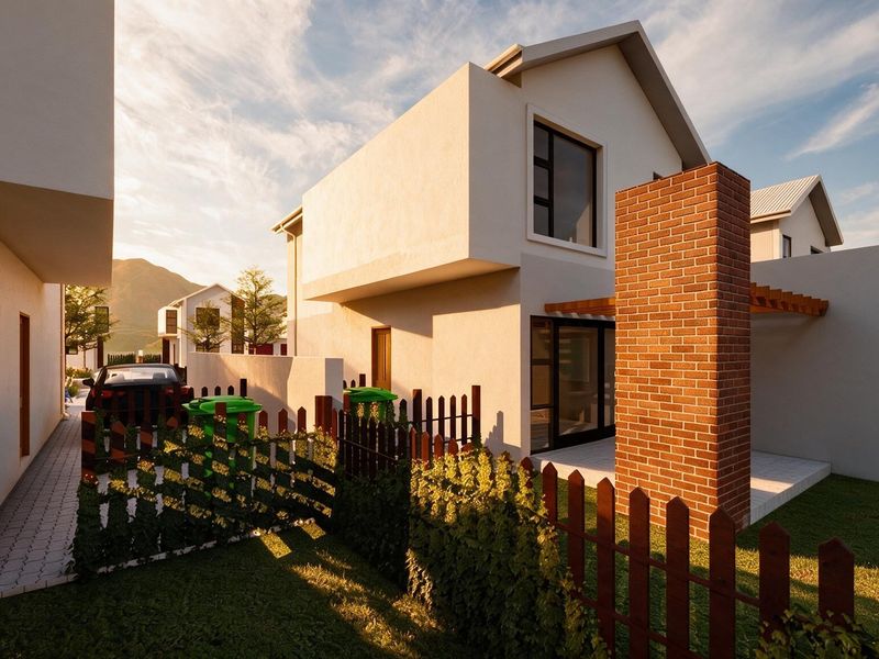 Rear view of a modern townhouse featuring a brick chimney, timber pergola, and a private paved patio area with garden fencing.