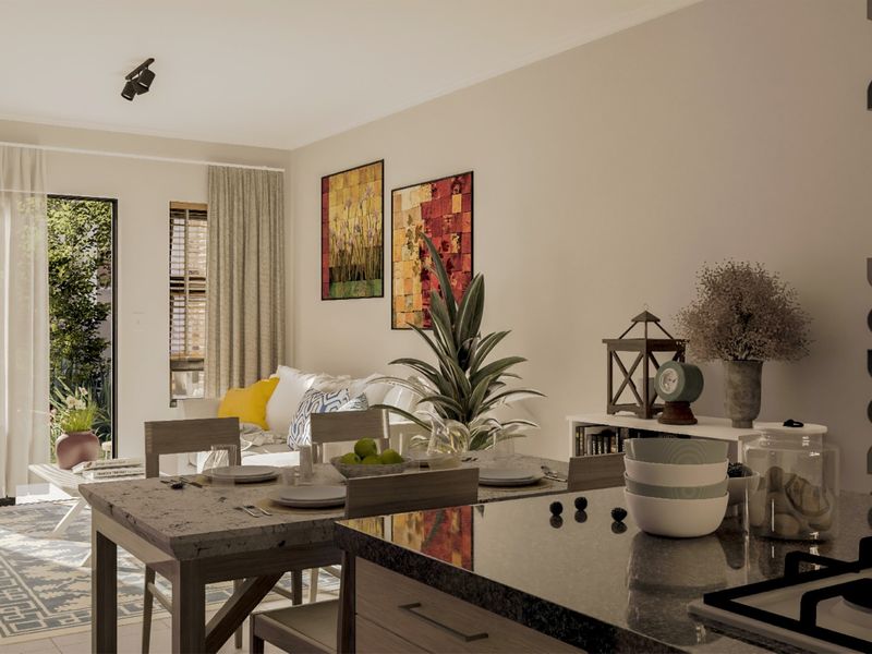 Modern open-plan living and dining area featuring a stone-topped kitchen island, integrated hob, and seamless access to an outdoor patio space.