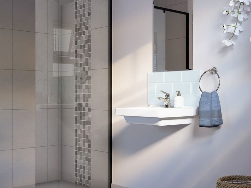 Modern bathroom featuring a walk-in shower with a black-framed glass screen, mosaic tile accents, and a sleek wall-mounted basin with subway tile splashback.