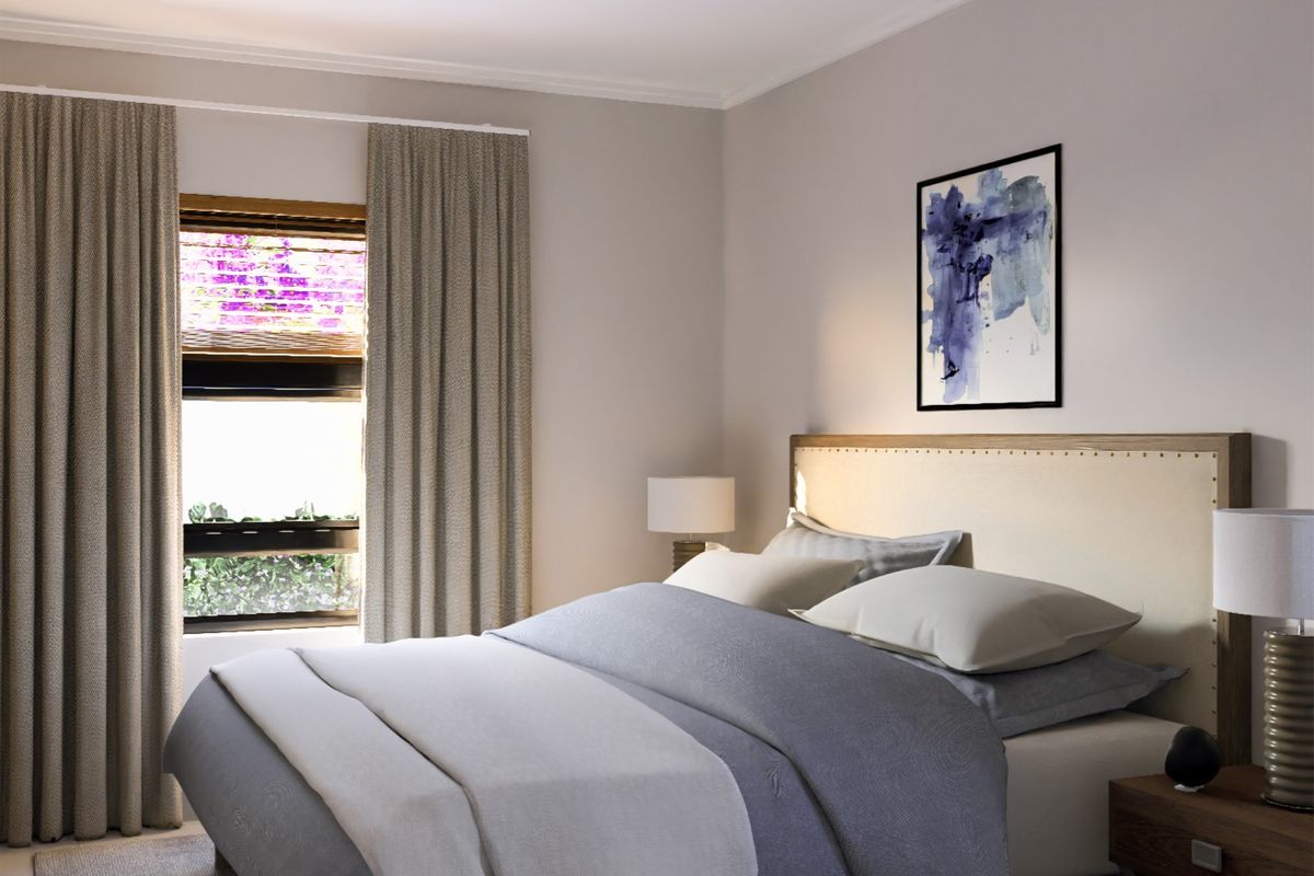 A well-maintained bedroom featuring neutral wall tones, coving, and a window with curtains, creating a comfortable and inviting sleeping space.