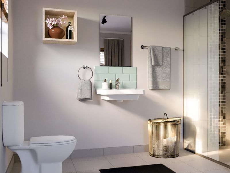 A modern, well-lit bathroom featuring a wall-mounted basin with a tiled splashback, a glass-enclosed shower, and a standard toilet.
