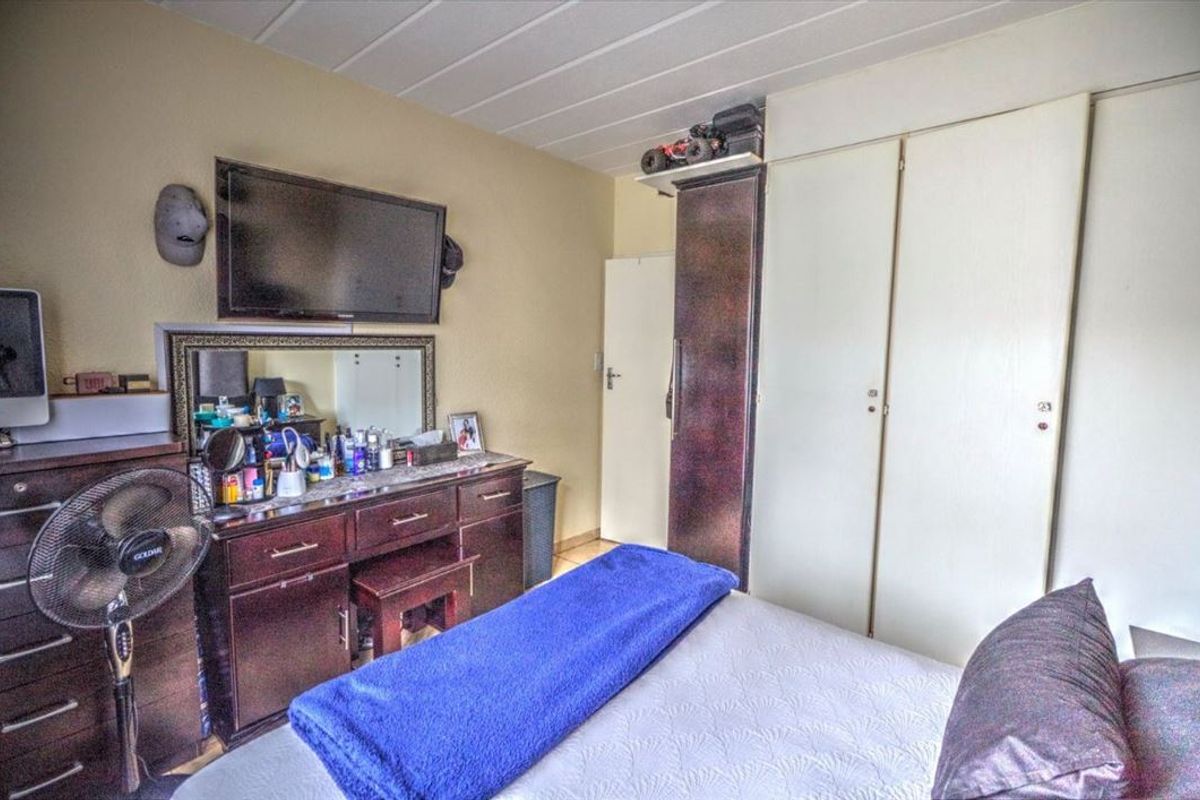 A bedroom featuring built-in cupboards and a panel ceiling, offering functional storage space within the apartment.