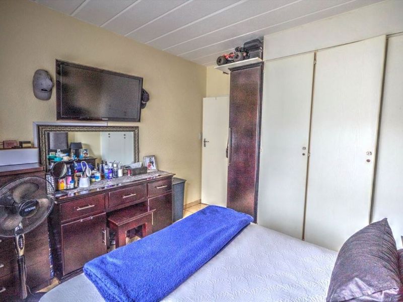 A bedroom featuring built-in cupboards and a panel ceiling, offering functional storage space within the apartment.
