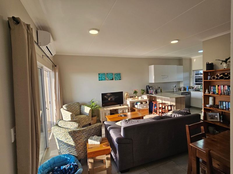 Open plan living area featuring tiled floors, recessed lighting, air conditioning, and a functional kitchen with island and cabinetry.