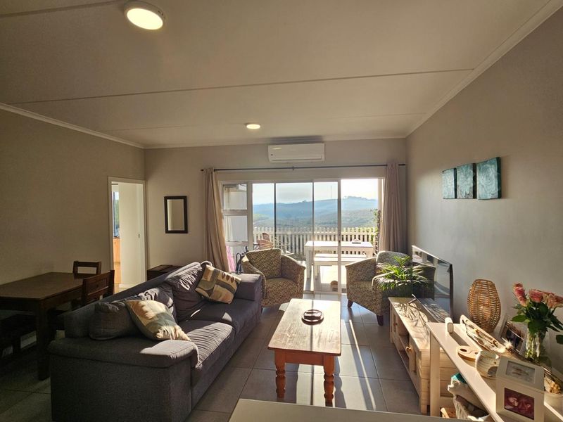 Open-plan living area featuring tiled floors, split-system air conditioning, and large sliding glass doors that provide natural light and access to the patio.