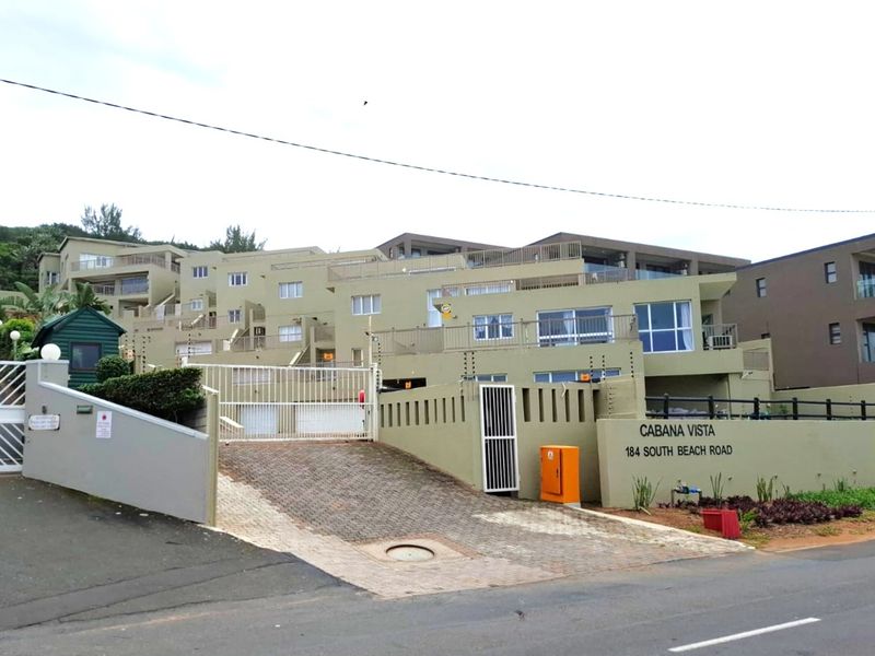 Front elevation of Cabana Vista apartment complex, featuring a paved driveway, secure gated entrance, and multi-level residential units with balconies.