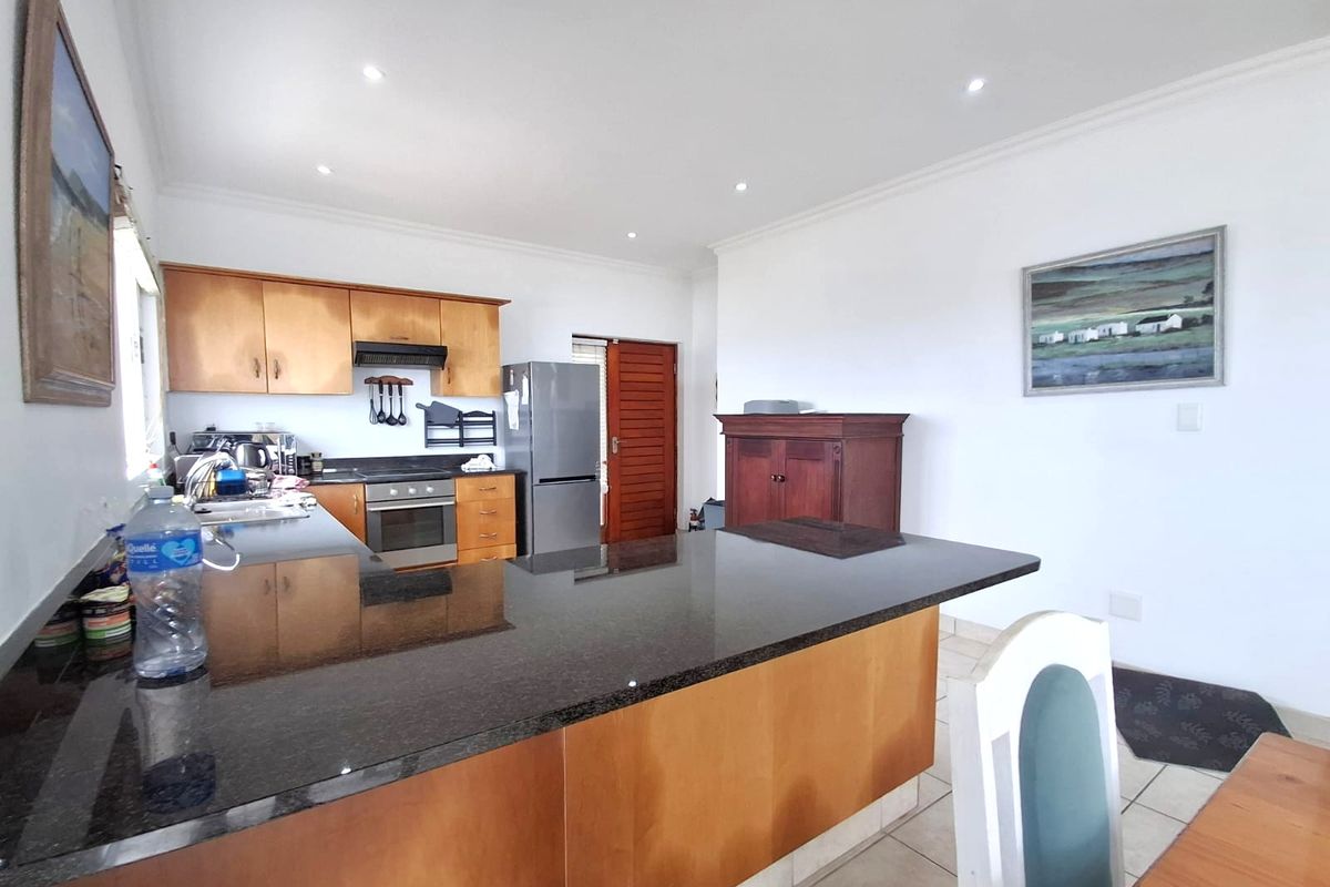 A functional kitchen featuring wooden cabinetry, granite countertops, a built-in oven, and recessed lighting, offering a practical layout for daily meal preparation.