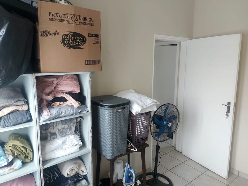 A utility or laundry area featuring tiled flooring and a standard internal door, currently used for storage.
