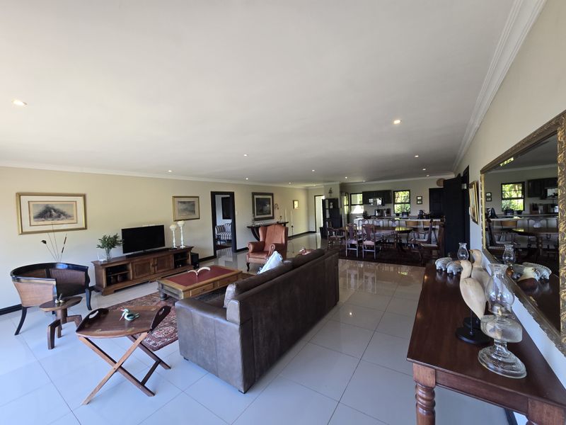 Spacious open-plan living and dining area featuring large format floor tiles, recessed lighting, and a seamless flow into the kitchen space.