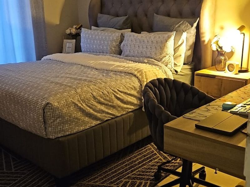 A cozy bedroom featuring tiled flooring and neutral wall tones, providing a comfortable and functional sleeping space.