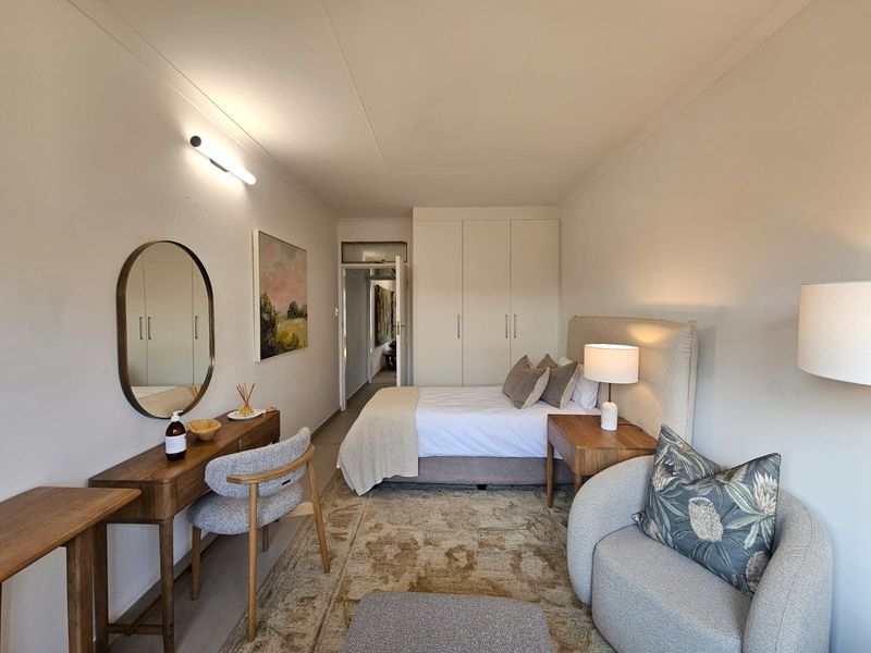 A well-maintained bedroom featuring built-in cupboards and neutral finishes, providing a comfortable and functional living space.