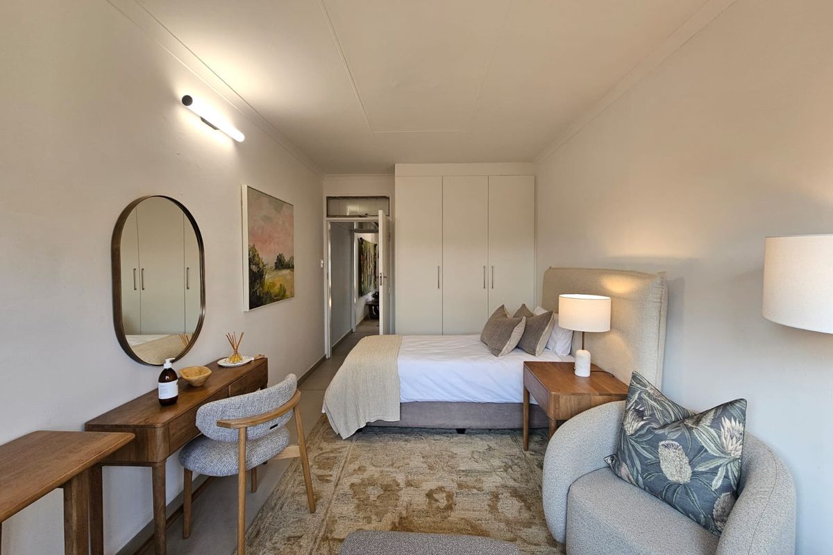 A well-maintained bedroom featuring built-in cupboards and neutral finishes, providing a comfortable and functional living space.