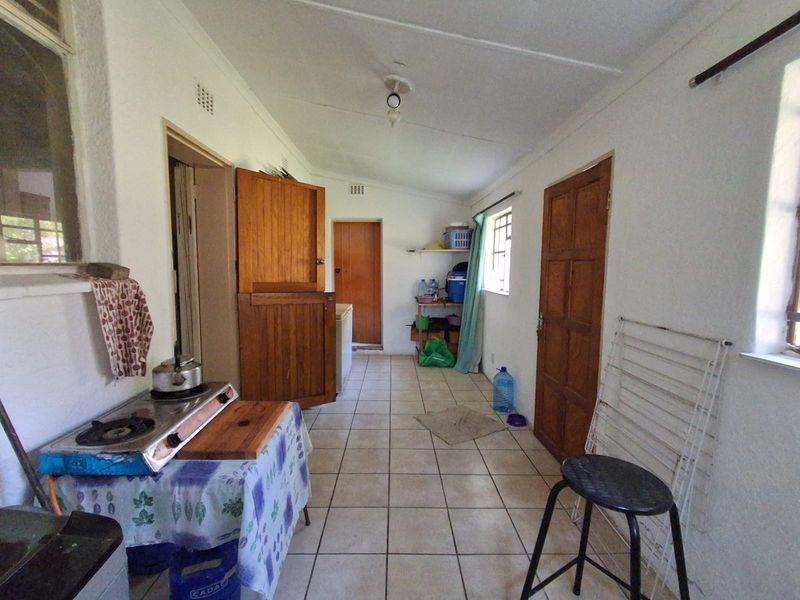 A functional laundry or utility space featuring tiled flooring and multiple wooden doors, providing access to other areas of the home.