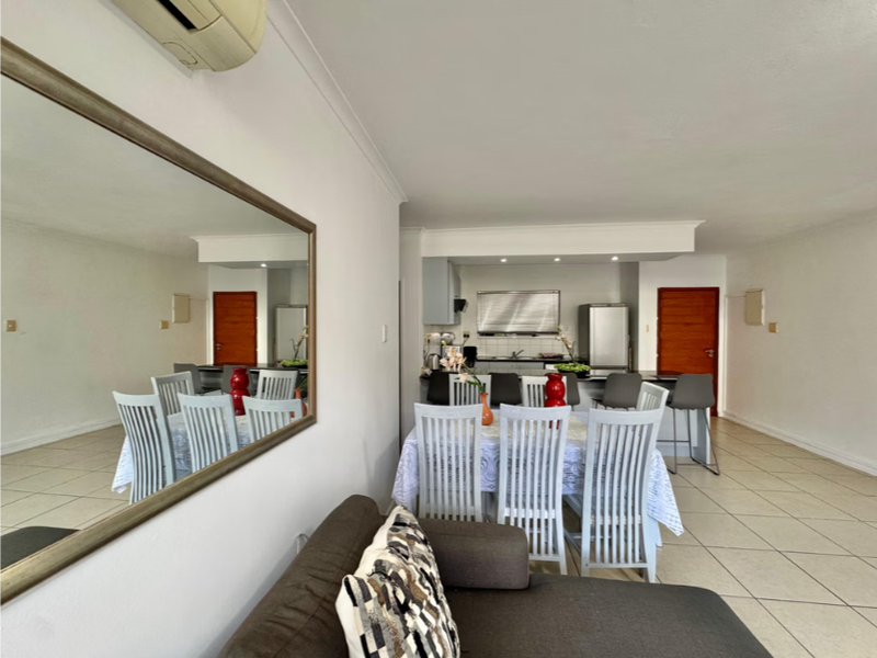 Open plan living and dining area featuring tiled flooring, recessed lighting, and a functional kitchen with a breakfast island.