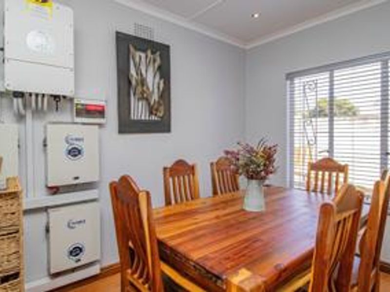 Dining room featuring a wall-mounted solar inverter and battery storage system, recessed lighting, and window blinds.