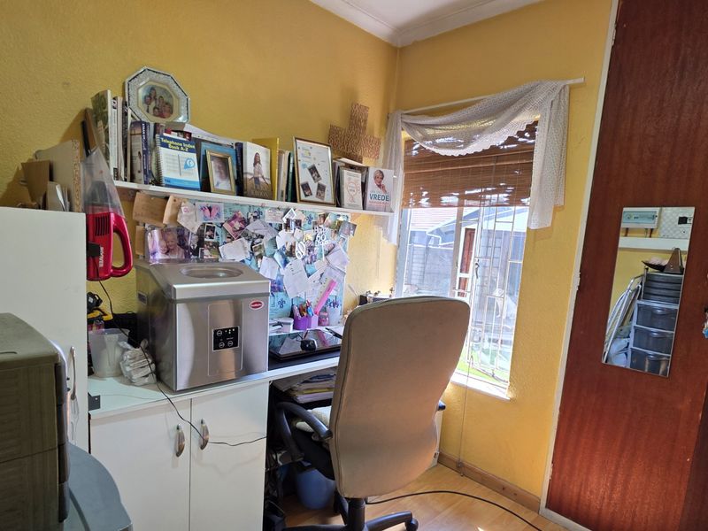 A functional home office space featuring laminate flooring, built-in shelving, and a built-in cupboard, providing a practical area for work or study.