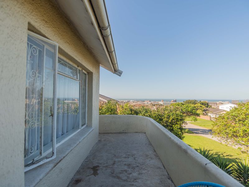 An elevated balcony featuring a solid masonry balustrade and expansive coastal views, offering a prime opportunity for outdoor renovation and enhancement.