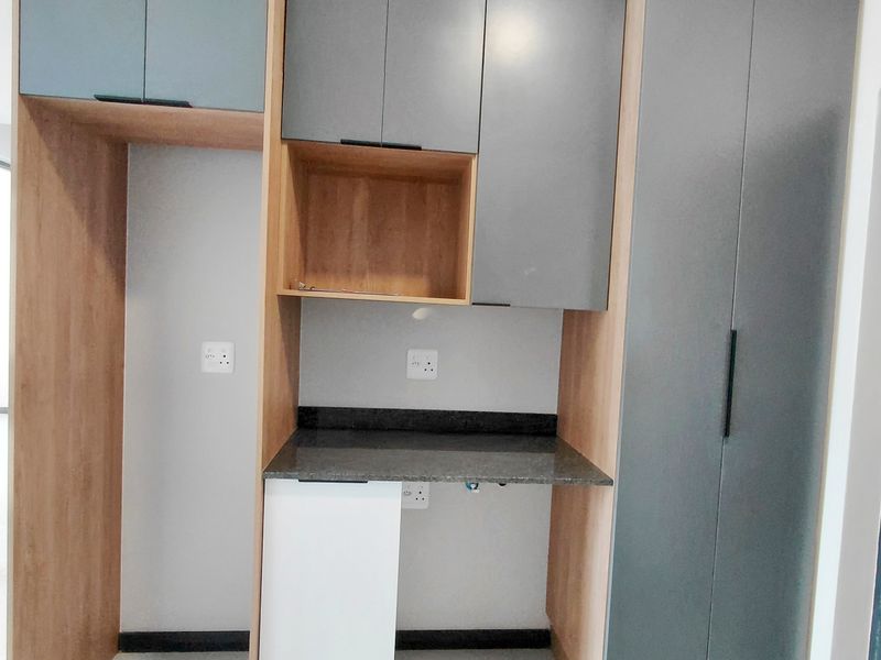 Modern kitchen cabinetry featuring built-in appliance housing, stone countertops, and ample storage space in a clean, contemporary finish.