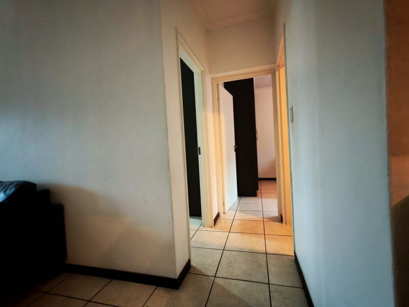 A functional hallway featuring tiled flooring and multiple internal doorways providing access to other areas of the apartment.