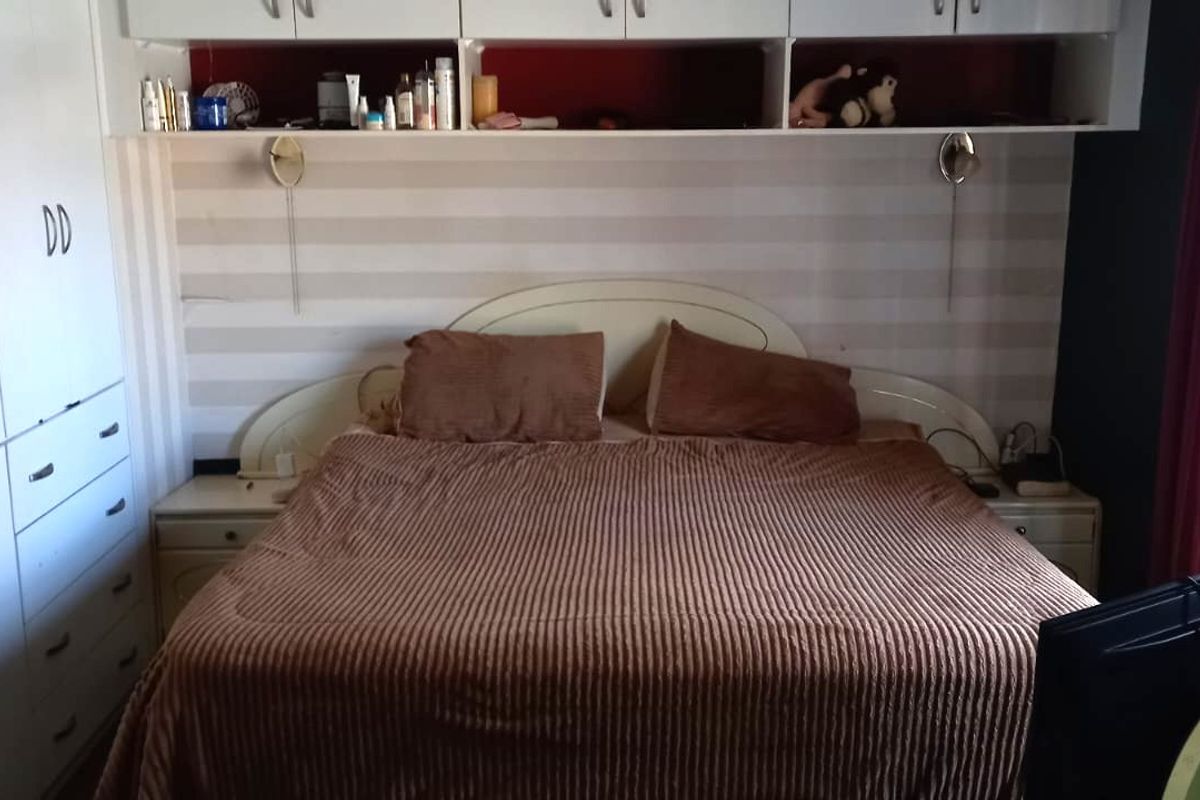 A bedroom featuring extensive built-in cabinetry, overhead storage units, and integrated wall-mounted lighting fixtures.