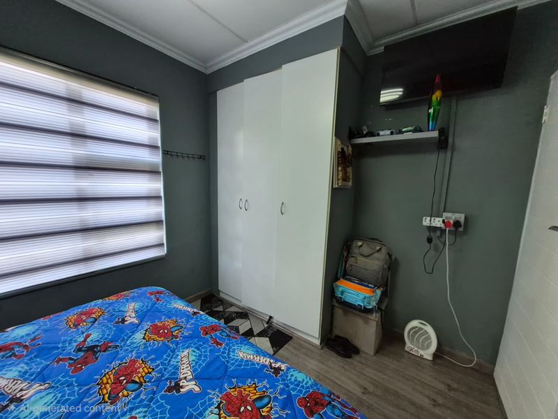 A bedroom featuring laminate flooring, built-in white wardrobes, and window blinds, providing a functional space with neutral wall tones.