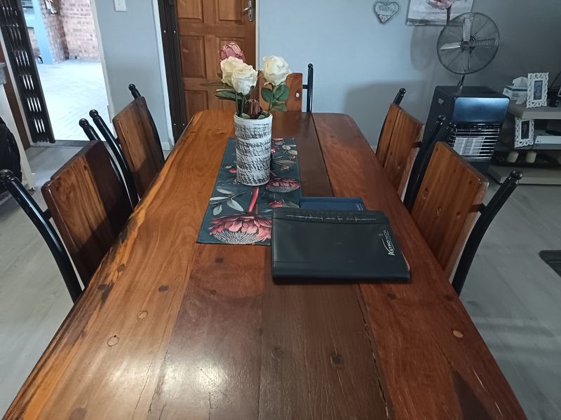 A dining area featuring laminate flooring and a wooden door, providing a functional space for meals.