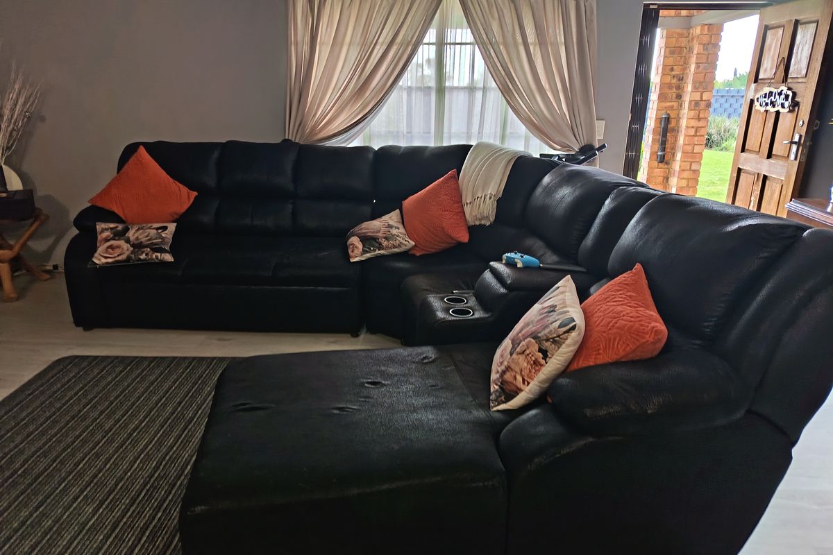A living room area featuring a window with curtains and direct access to an outdoor space through a wooden door.