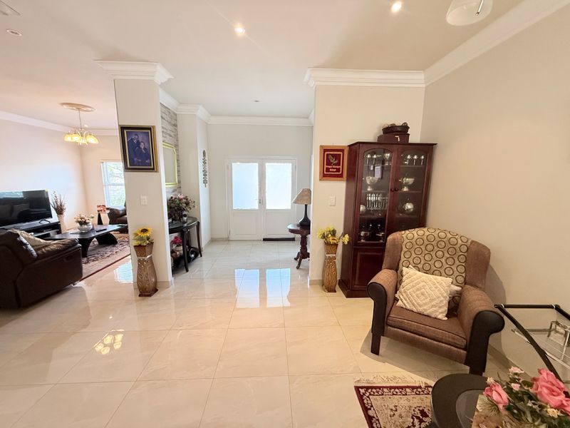 Spacious entrance hall featuring polished tiled flooring, crown molding, and recessed downlighting, providing a bright and welcoming transition into the main living areas.