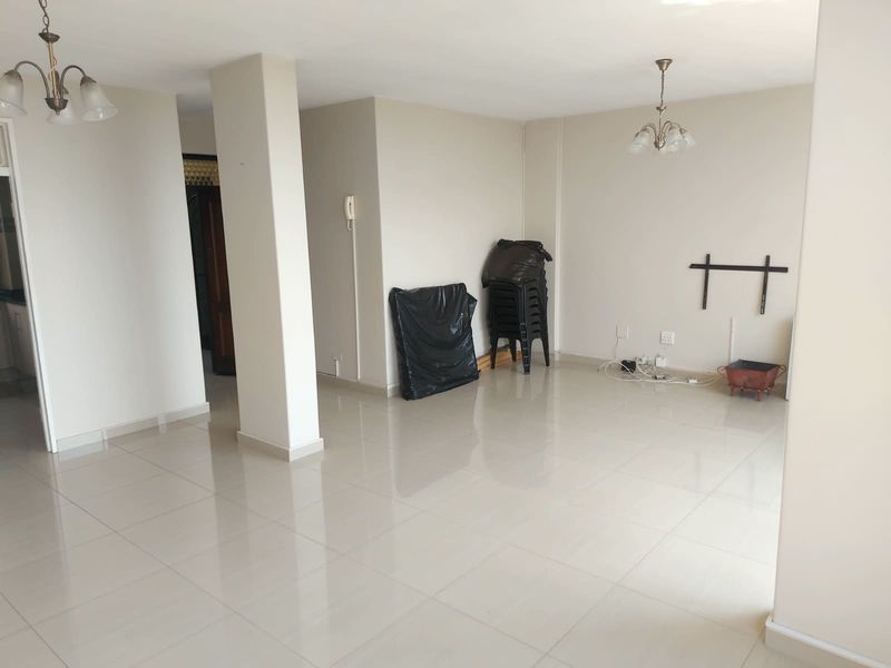 A spacious, neutral-toned living area featuring polished tile flooring, ceiling light fixtures, and an intercom system, offering a clean and versatile blank canvas.