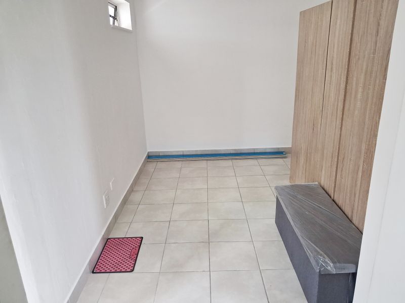 A clean, empty bedroom featuring neutral tiled flooring and modern built-in cupboards, offering a blank canvas for personalization.