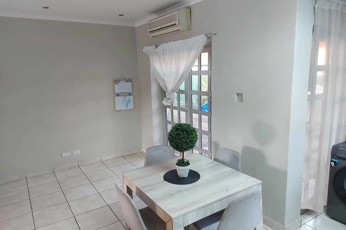 A functional living area featuring tiled flooring, recessed lighting, and an integrated air conditioning unit with direct access to an outdoor space.