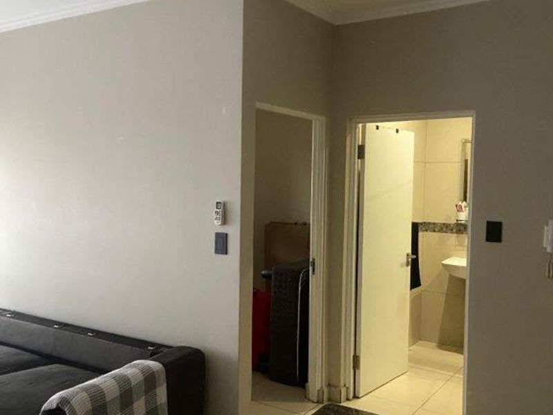 Open plan living area featuring tiled flooring, granite countertop, and recessed lighting, with direct access to a bathroom and adjacent utility space.