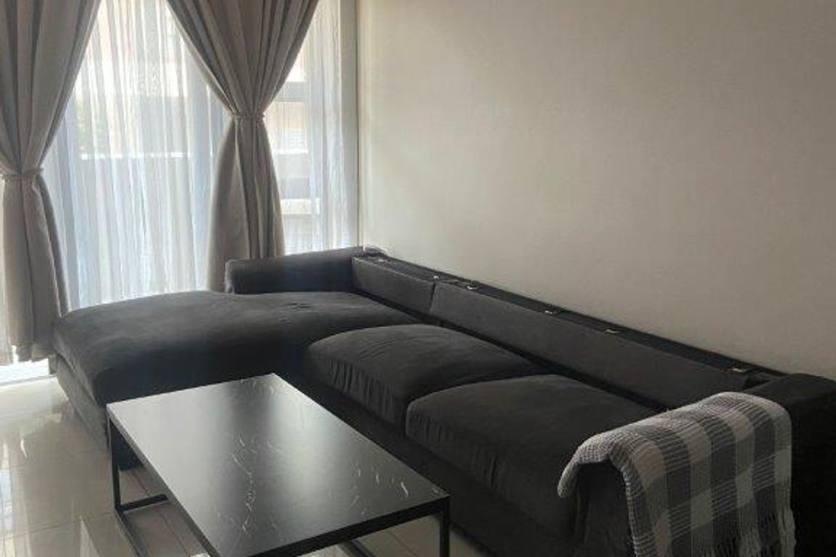 A comfortable living room featuring tiled flooring and a wall-mounted split-system air conditioner, providing a functional and well-maintained space.