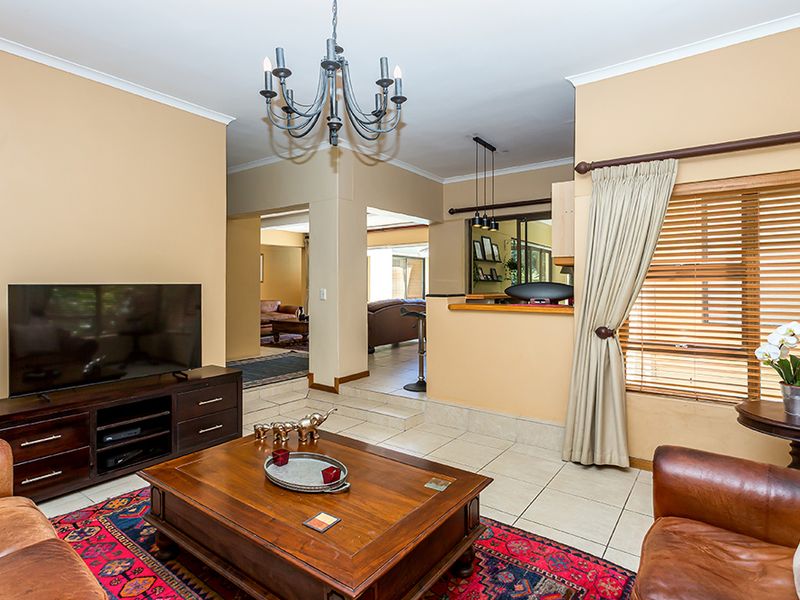Spacious living area featuring tiled flooring, a breakfast bar pass-through to the kitchen, and neutral wall tones, offering a comfortable and functional layout.