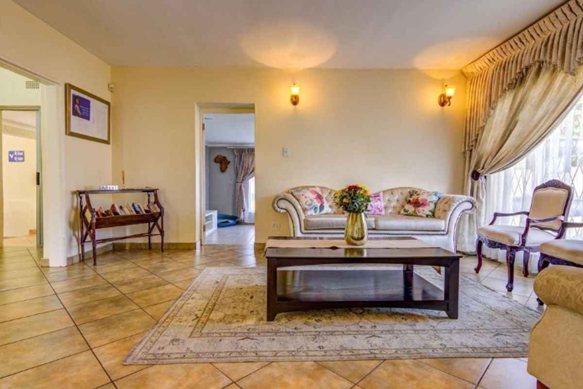 A comfortable living room featuring tiled flooring and warm wall sconce lighting, providing a functional and inviting space for relaxation.
