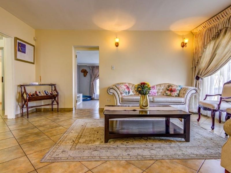 A comfortable living room featuring tiled flooring and warm wall sconce lighting, providing a functional and inviting space for relaxation.