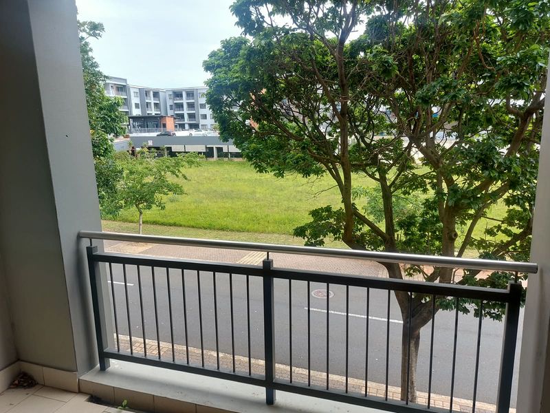 A private balcony featuring a metal balustrade, offering an elevated view of the street and surrounding neighborhood.