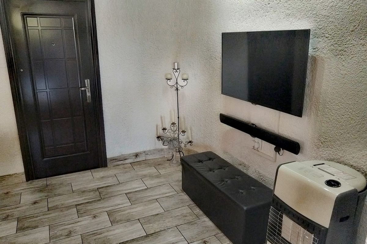A living area featuring textured walls and wood-look ceramic floor tiles, providing a neutral base for interior design updates.