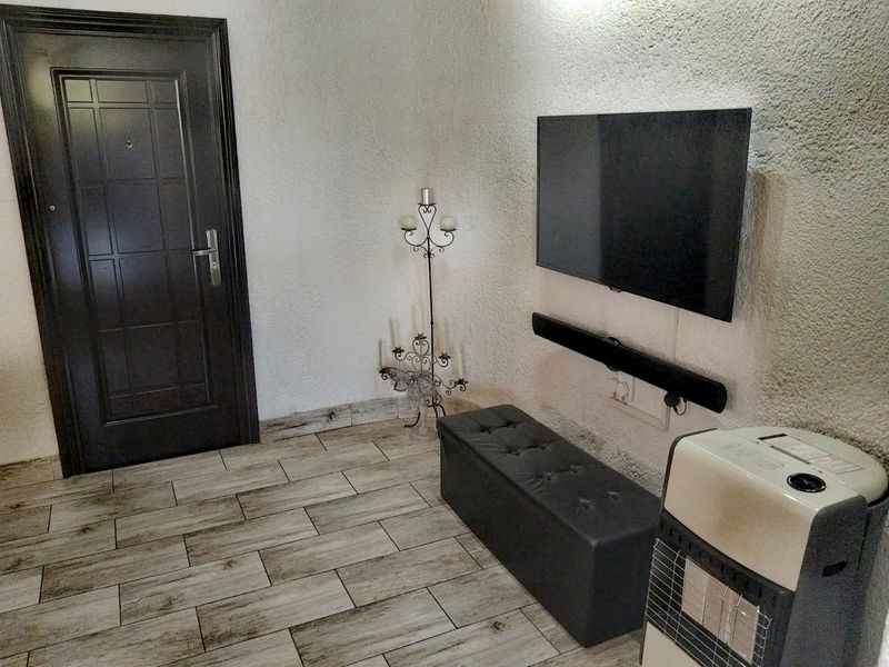 A living area featuring textured walls and wood-look ceramic floor tiles, providing a neutral base for interior design updates.