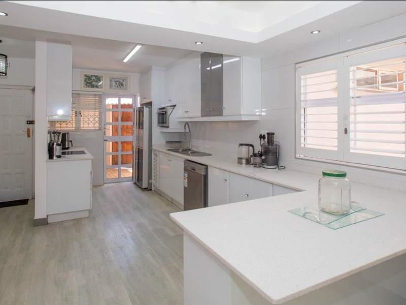 Modern kitchen featuring white cabinetry, quartz countertops, integrated appliances, and recessed lighting, offering a clean and functional workspace.