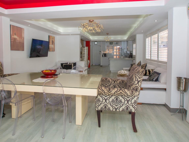 Spacious open-plan living and dining area featuring modern laminate flooring, recessed ceiling lighting, and a seamless transition into the kitchen space.