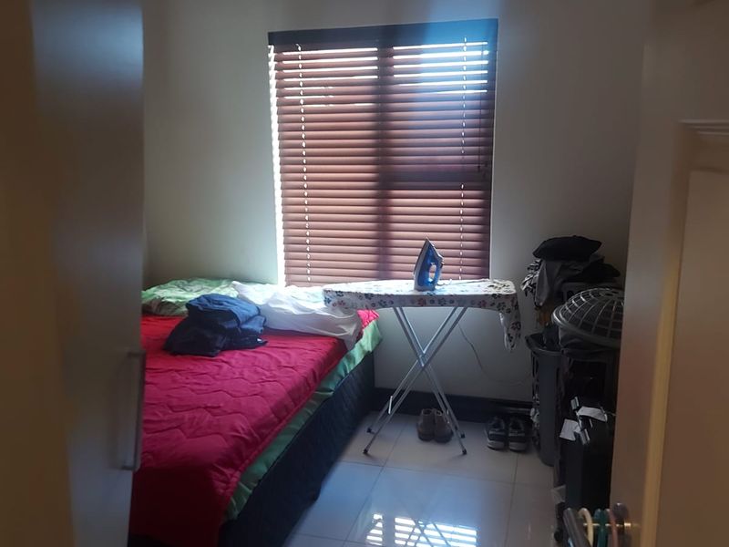 A bedroom featuring tiled flooring, coved ceiling details, and venetian blinds, viewed from the doorway.