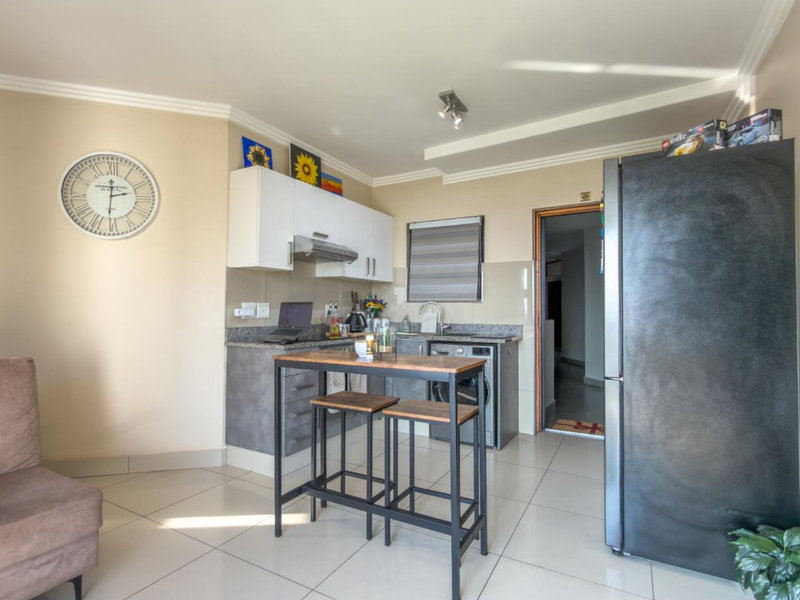 Open-plan kitchen area featuring granite countertops, modern cabinetry, and tiled flooring, seamlessly integrated into the living space.
