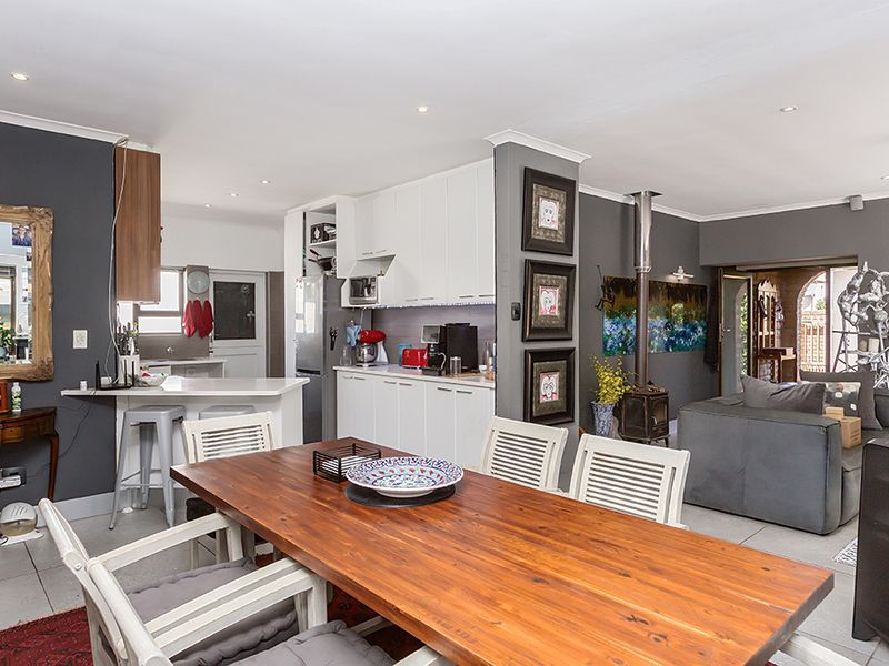 Spacious open-plan living area featuring a modern kitchen with island, dining space, and a cozy fireplace, creating a functional and connected home environment.