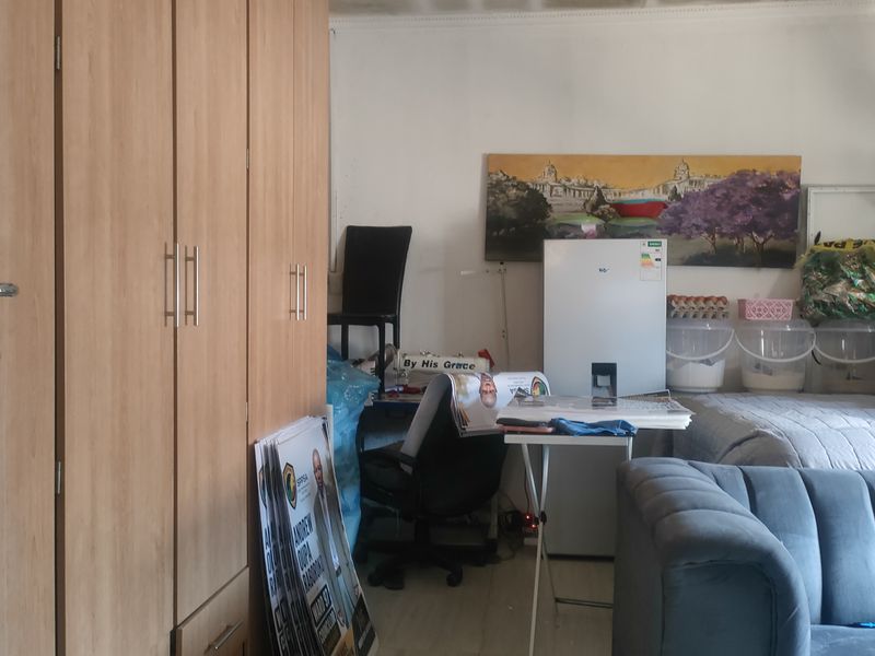 A bedroom featuring built-in wooden cupboards, showing signs of wear and requiring cosmetic updates to improve the overall aesthetic.