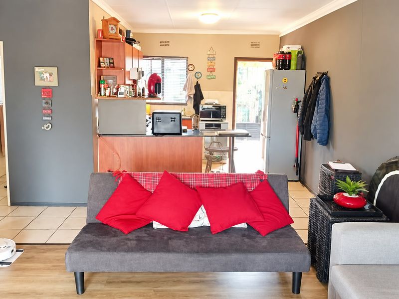 Open-plan living area featuring a combined kitchen and lounge space with tiled and laminate flooring, providing a functional layout for modern apartment living.