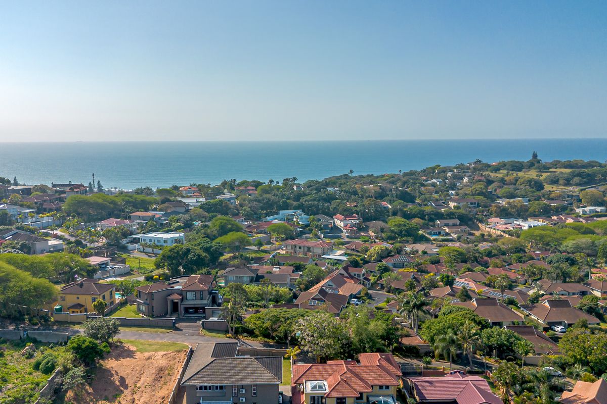 An elevated aerial view showcasing the surrounding residential neighborhood and coastal landscape.