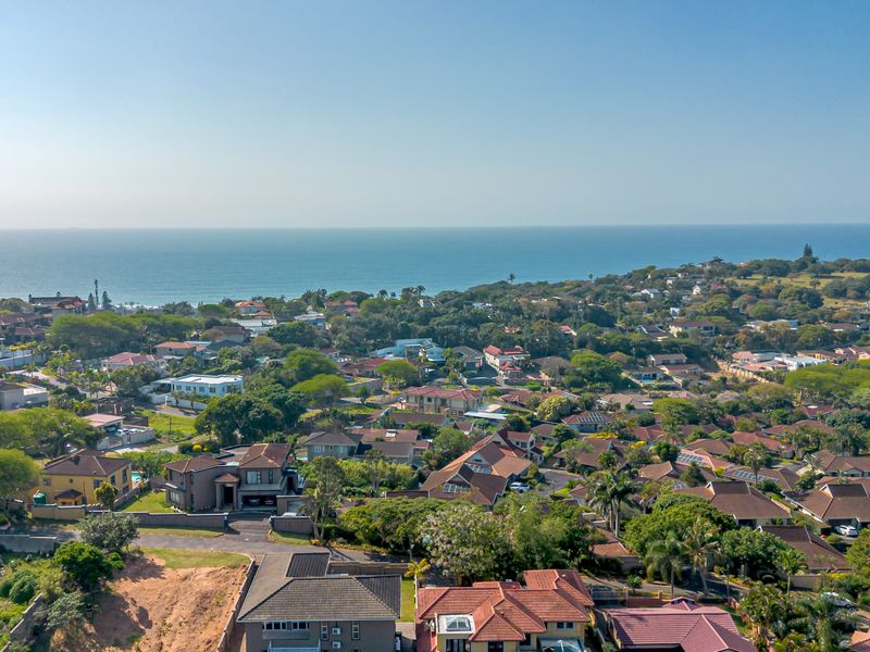 An elevated aerial view showcasing the surrounding residential neighborhood and coastal landscape.