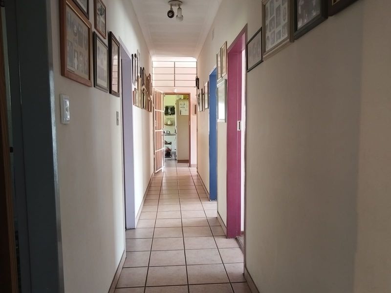 A functional hallway featuring tiled flooring and multiple doorways, providing access to various rooms within the townhouse.