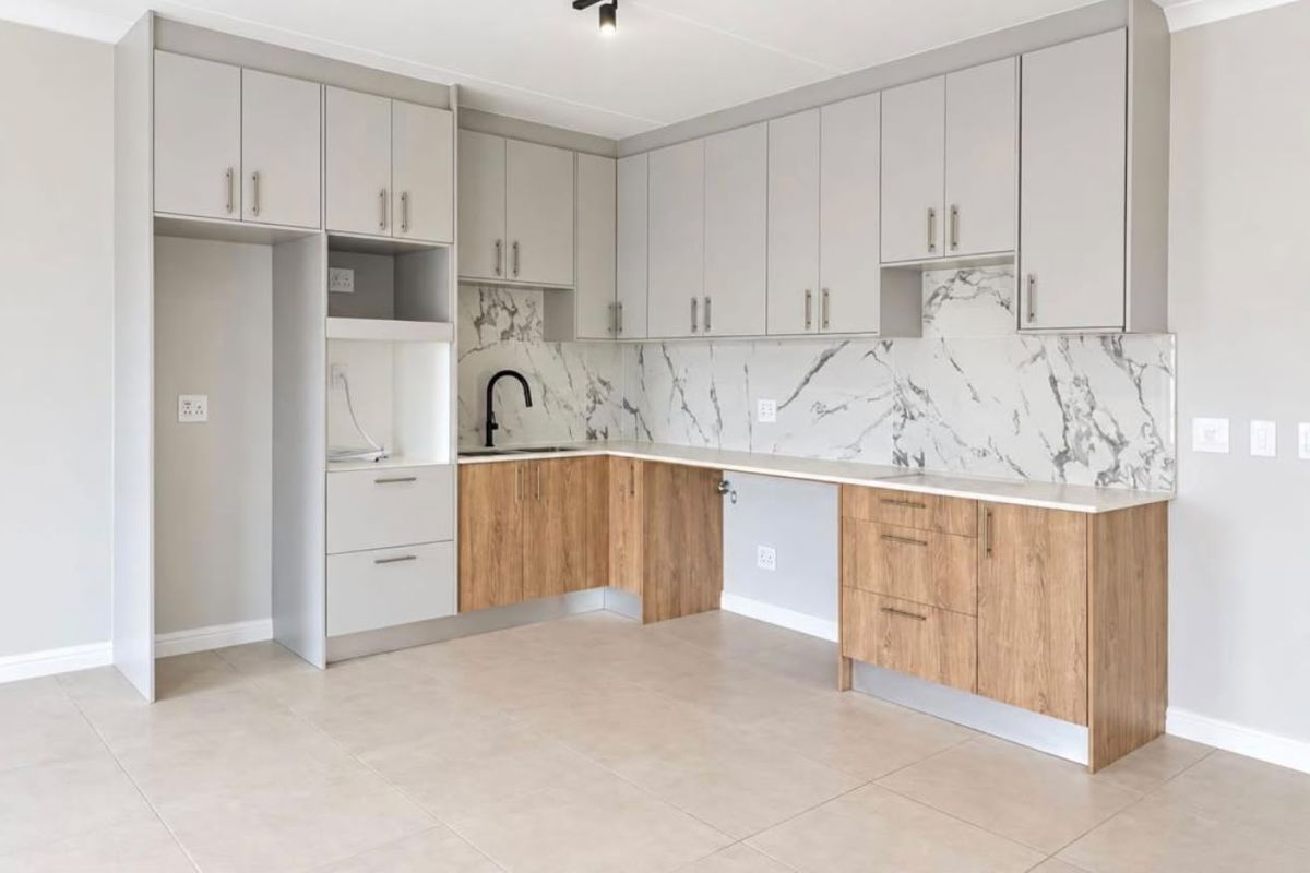 Modern kitchen featuring two-tone cabinetry, marble-look splashback, stone countertops, and high-quality finishes in an open-plan layout.